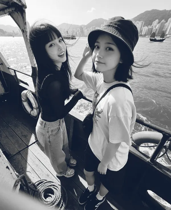 Two friends on a boat deck in cold black and white.