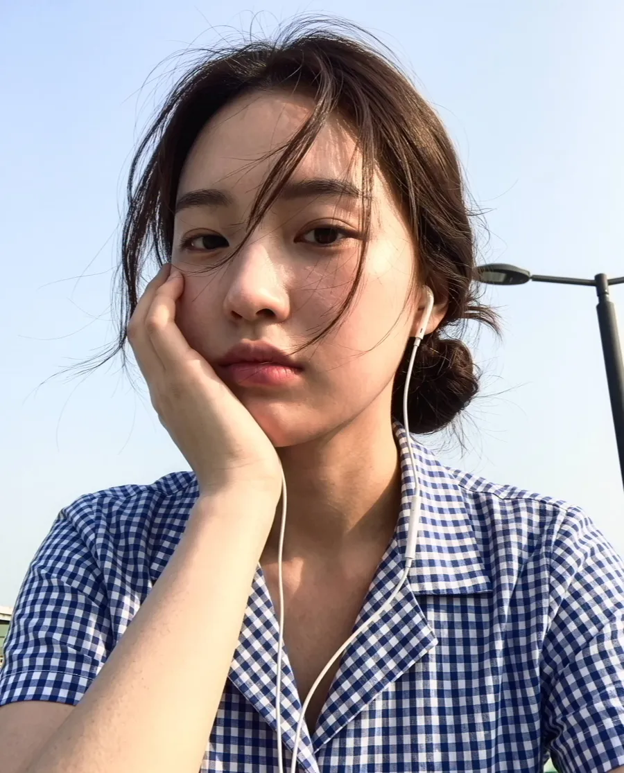 A selfie of a girl resting her chin on her hand, through HR-6: clean and detailed.